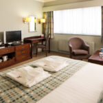 Angled view of Double bed desk and HDTV in a Privilege Room at Mercure Hotels