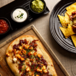 Nachos, pizza and dip sharer platter with red wine