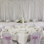 White and pink place settings at the head table of a wedding at Mercure Hotels