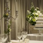 Four tier white wedding cake on a table at a wedding in a Mercure Hotel