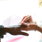 Bride places a ring on her groom's finger
