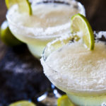 Two frozen margaritas with lime and salt