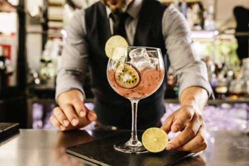 Barman serves a cocktail in large glass