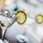 Two glasses of classic martinis with ice on a hot Summer day. Selective focus on the foreground glass.