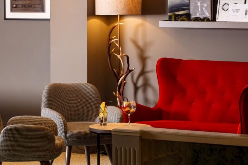Detail of a red sofa and chairs in the lounge area at mercure inverness hotel