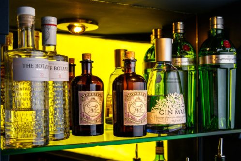 Close up of gin bottles on glass shelf in bar