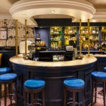 Wide shot of the bar area at mercure inverness hotel with blue stools arranged around the bar