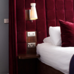 Purple headboard and glimpse into the bathroom in a mercure inverness hotel purple privilege bedroom