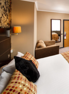 Double bed with desk and HD TV and separate seating area in mercure inverness hotel superior bedroom